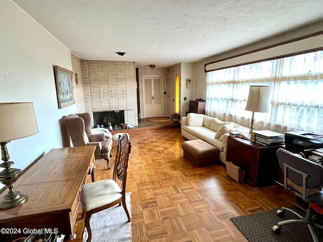 living room with a fireplace, light parquet floors, and a textured ceiling