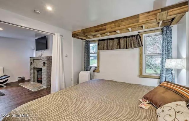 bedroom with wood-type flooring and a fireplace