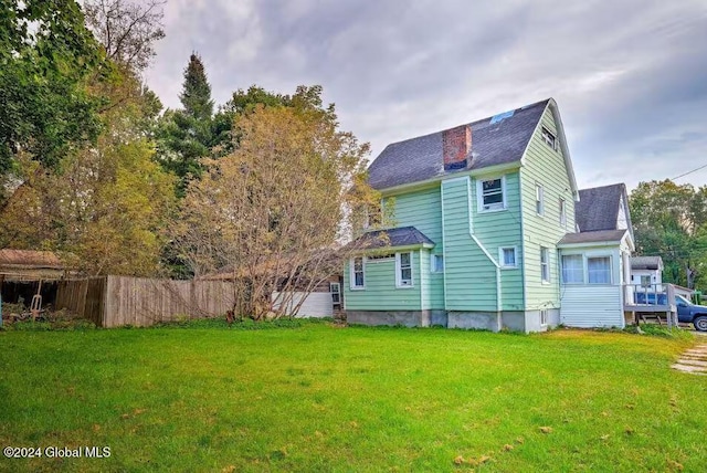 rear view of property with a lawn