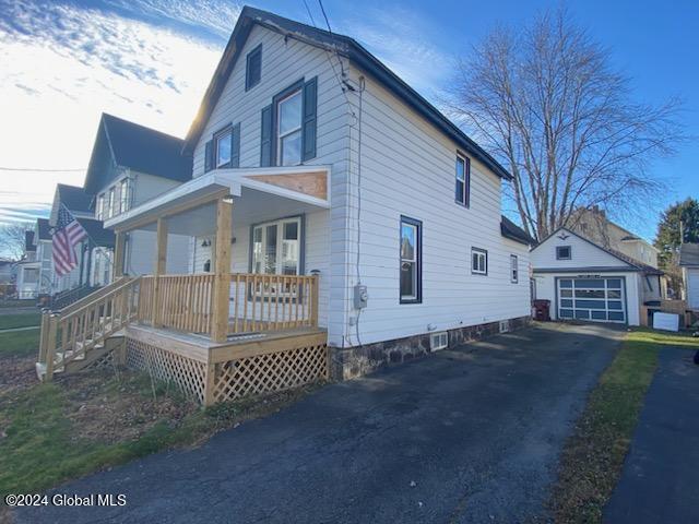 view of home's exterior featuring an outbuilding, a porch, and a garage