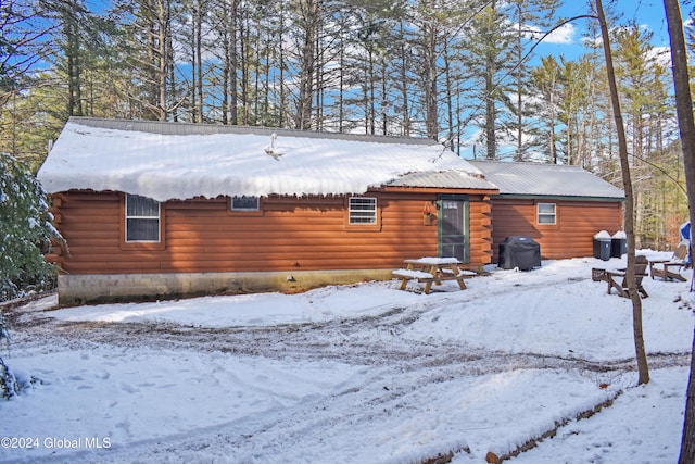 view of snow covered back of property