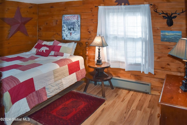 bedroom featuring baseboard heating, wood walls, and hardwood / wood-style flooring