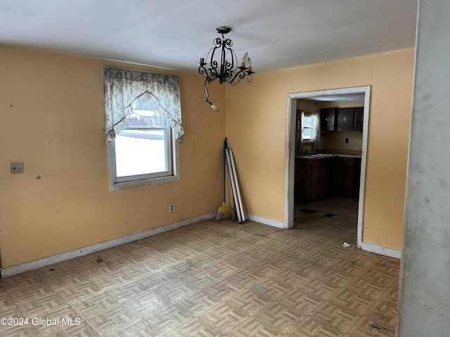 unfurnished dining area featuring light parquet floors, a notable chandelier, and sink