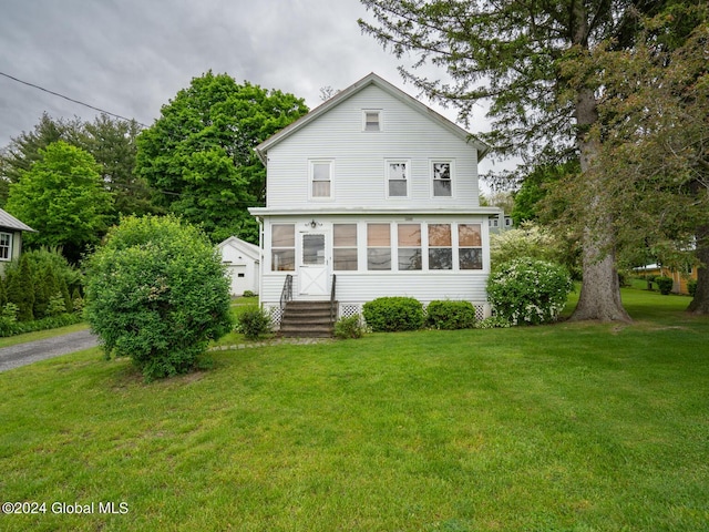 back of house with a lawn and a sunroom