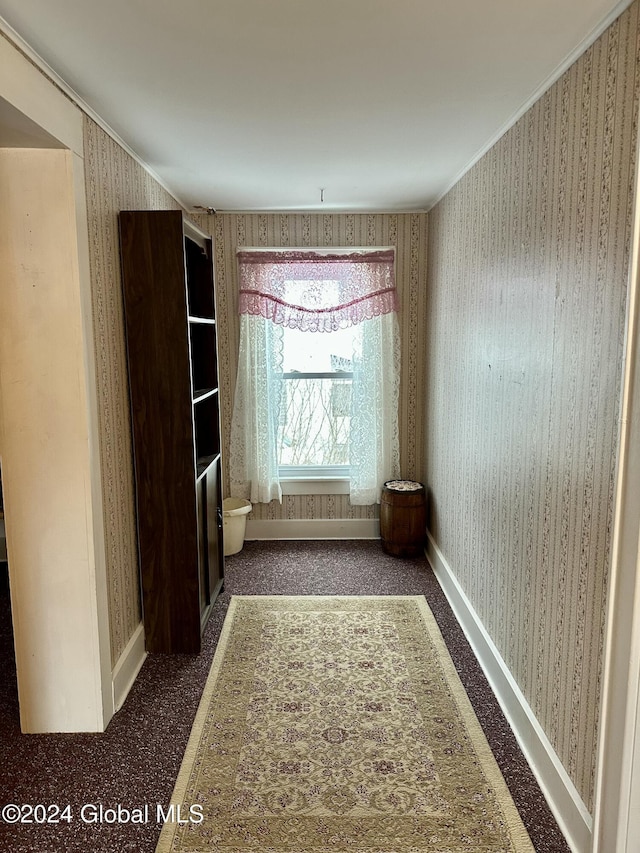 spare room with dark colored carpet and ornamental molding