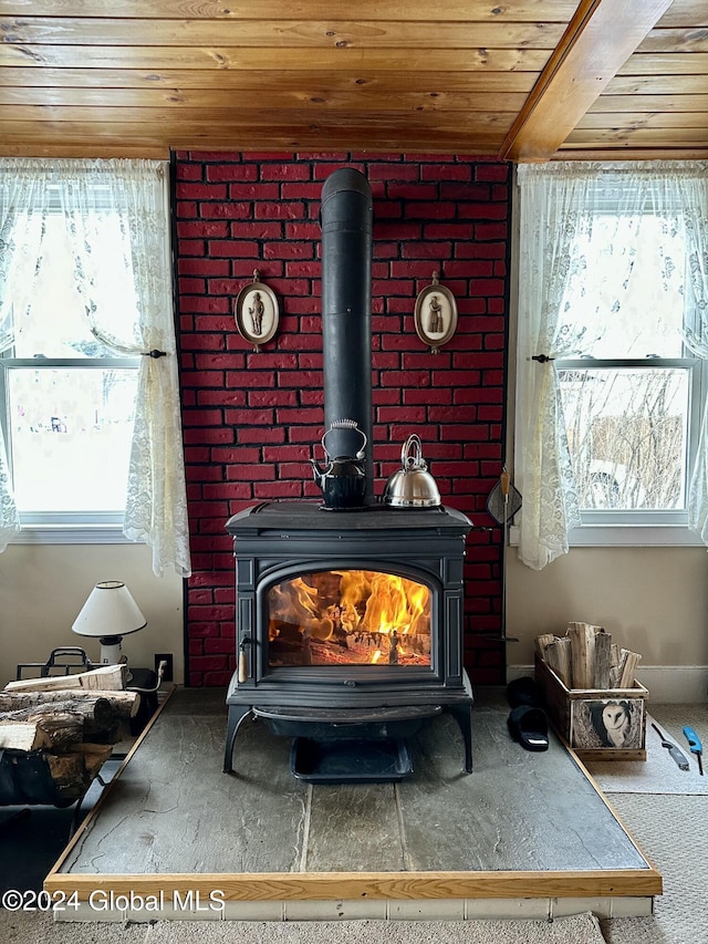 room details featuring beamed ceiling, a wood stove, and wood ceiling