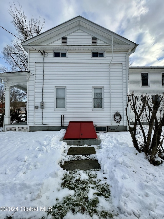 view of snow covered back of property