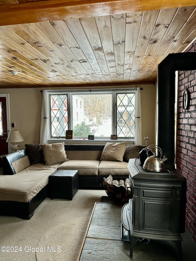 living area featuring a wood stove, carpet floors, wooden ceiling, and brick wall