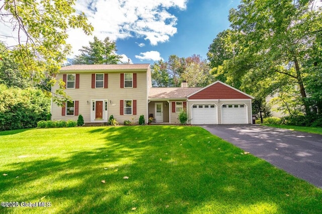 colonial inspired home with a garage and a front yard