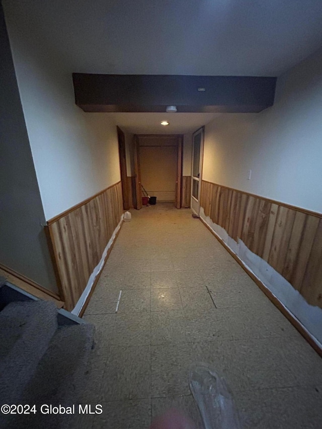 hallway featuring wooden walls