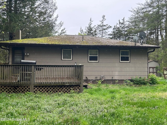 rear view of house featuring a lawn and a wooden deck