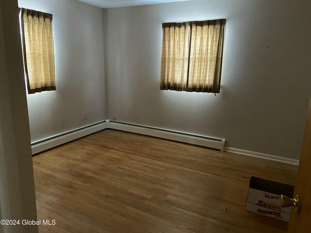 spare room featuring hardwood / wood-style flooring and baseboard heating