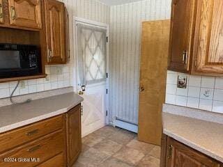 kitchen with decorative backsplash and a baseboard radiator