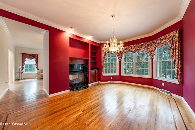 unfurnished dining area featuring a fireplace, hardwood / wood-style flooring, and crown molding