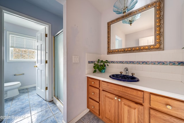 bathroom featuring tile patterned flooring, vanity, walk in shower, and tasteful backsplash