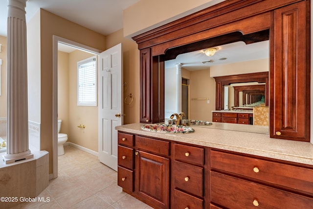 bathroom featuring toilet, tile patterned floors, vanity, and ornate columns