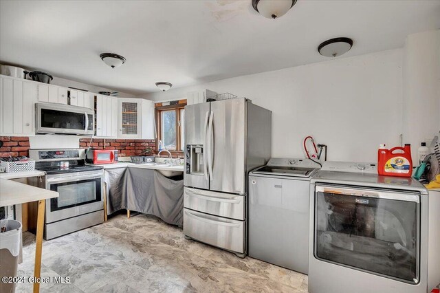 kitchen featuring tasteful backsplash, washer and dryer, white cabinets, and stainless steel appliances