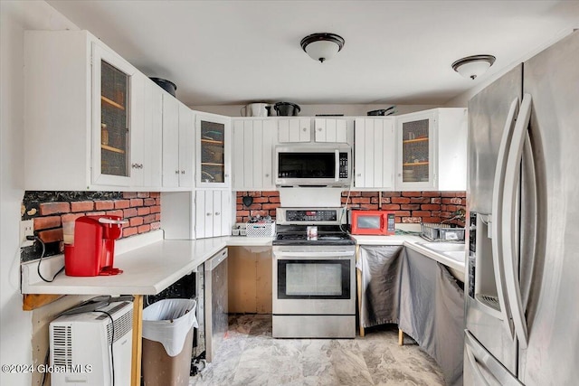 kitchen with backsplash, white cabinetry, and stainless steel appliances