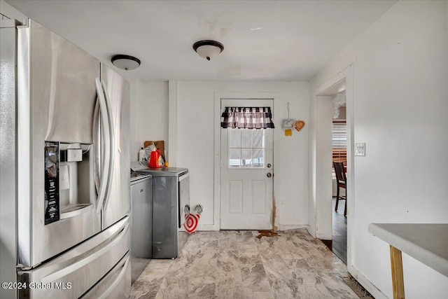 kitchen with washer and clothes dryer and stainless steel refrigerator with ice dispenser