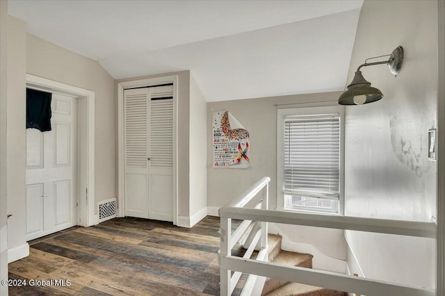 hall featuring dark hardwood / wood-style floors and vaulted ceiling