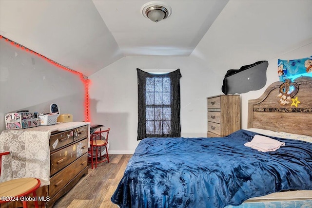 bedroom with wood-type flooring and vaulted ceiling