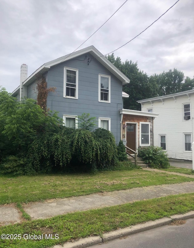 24 Wagner St, Fort Plain, NY 13339 - view of front of home featuring a chimney and a front lawn