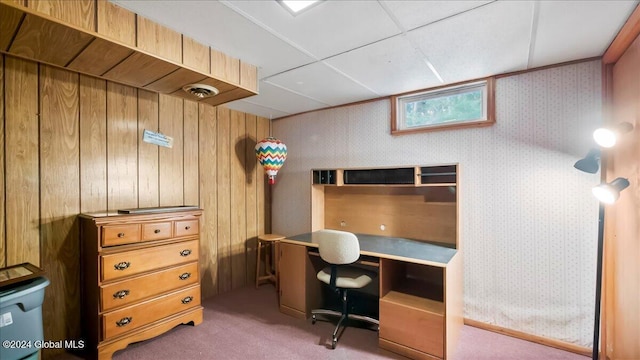 carpeted office space featuring wooden walls