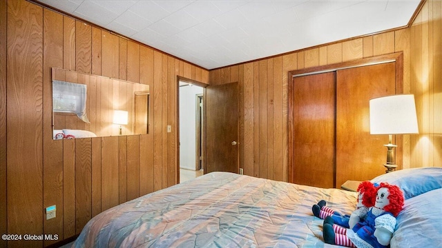 bedroom with a closet and wooden walls