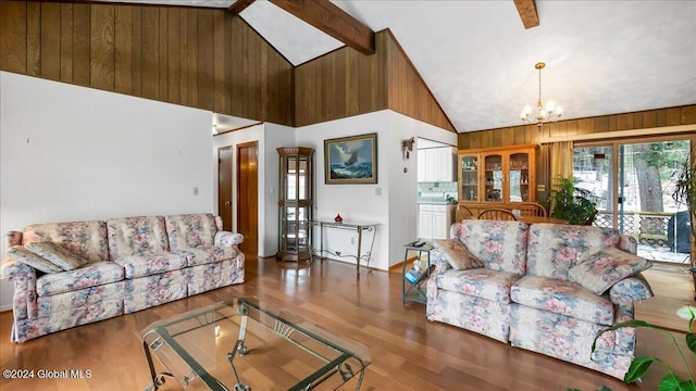 living room with beam ceiling, high vaulted ceiling, a chandelier, wood-type flooring, and wooden walls