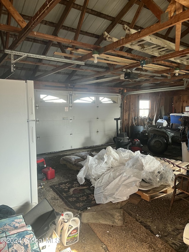 garage featuring a garage door opener and freestanding refrigerator