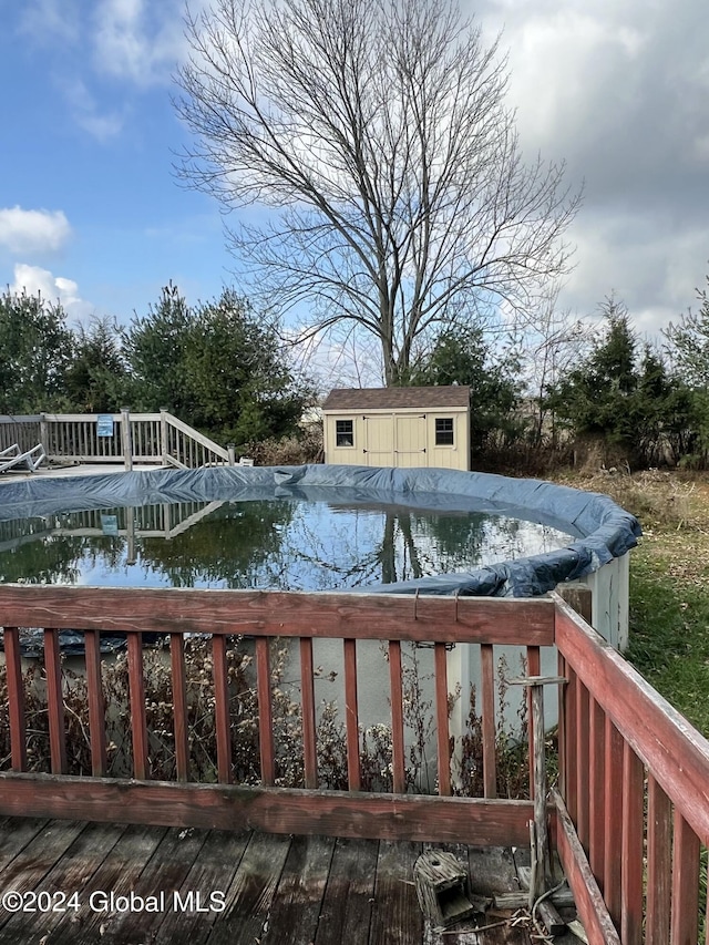 view of swimming pool with a covered pool, an outdoor structure, and a storage unit