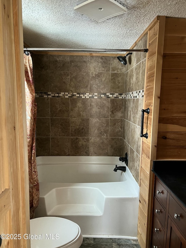 bathroom featuring vanity, shower / tub combo with curtain, toilet, and a textured ceiling