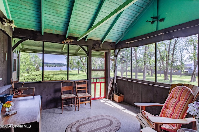 sunroom / solarium with plenty of natural light, a water view, and vaulted ceiling