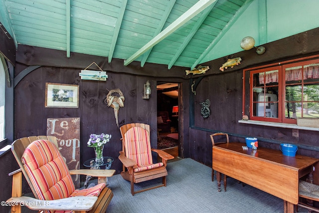 sitting room with lofted ceiling with beams, wood ceiling, and wood walls