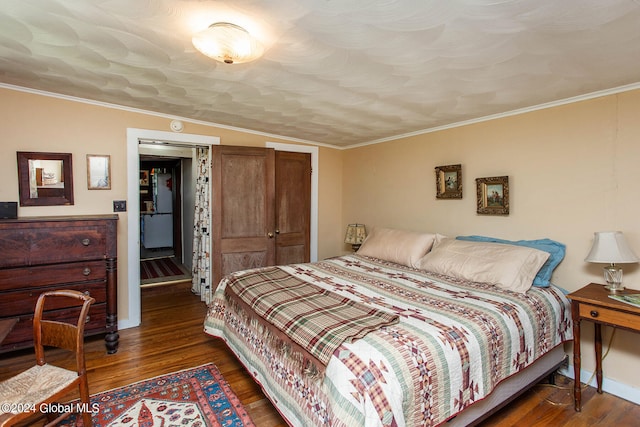 bedroom featuring dark hardwood / wood-style flooring, vaulted ceiling, and crown molding