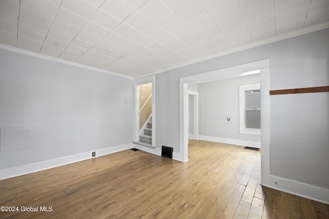 unfurnished room with hardwood / wood-style flooring and ornamental molding