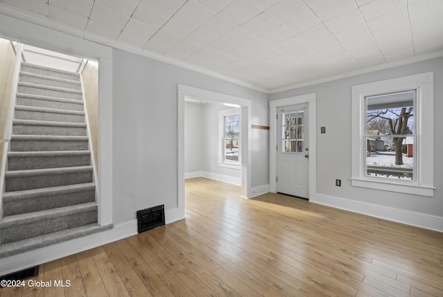 foyer entrance featuring light hardwood / wood-style floors and ornamental molding