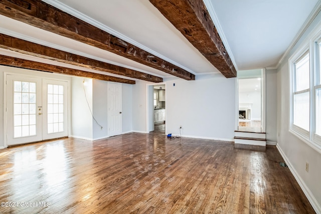 unfurnished living room featuring beam ceiling, ornamental molding, dark wood-type flooring, and french doors