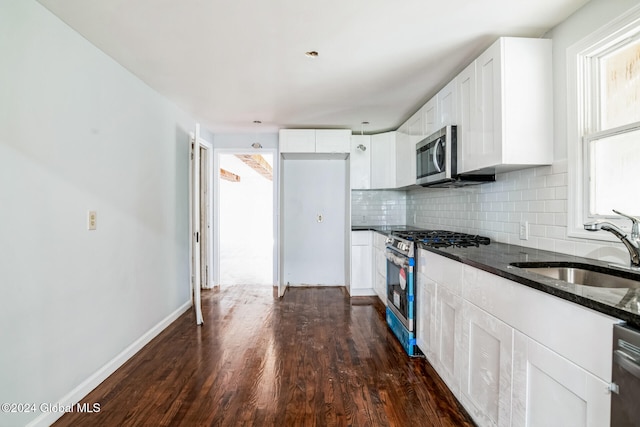 kitchen featuring dark hardwood / wood-style floors, white cabinetry, sink, and appliances with stainless steel finishes