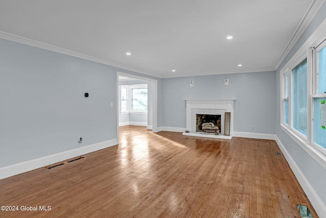 unfurnished living room featuring a fireplace, light hardwood / wood-style flooring, and ornamental molding