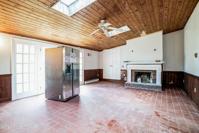 unfurnished living room with plenty of natural light, ceiling fan, wooden ceiling, and a baseboard heating unit