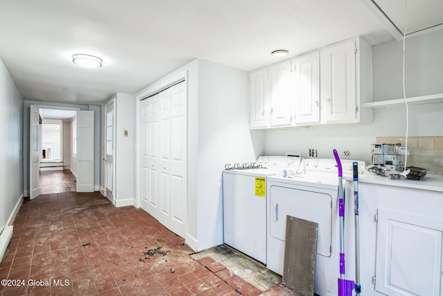 laundry area with baseboard heating, washer and clothes dryer, and cabinets