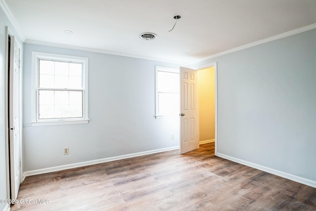 spare room with crown molding and hardwood / wood-style floors