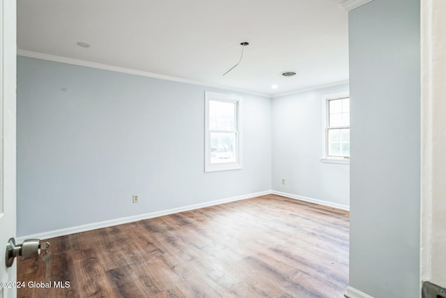 unfurnished room featuring hardwood / wood-style floors, a healthy amount of sunlight, and ornamental molding