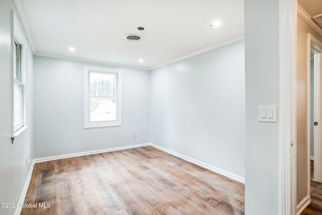 empty room featuring light hardwood / wood-style floors and ornamental molding