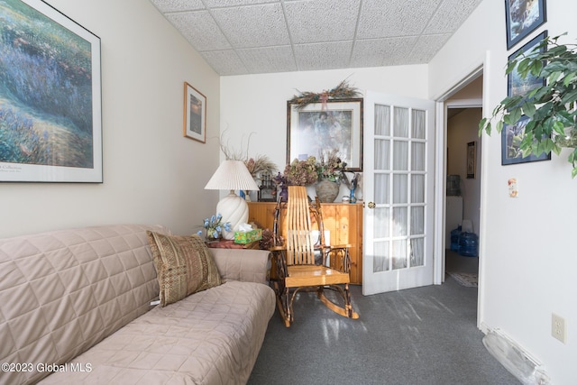 carpeted living room with a drop ceiling