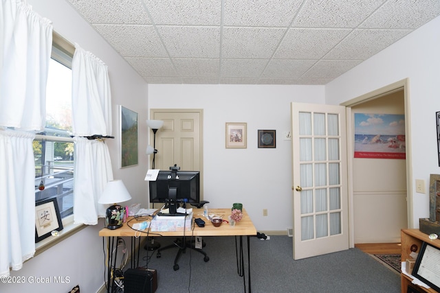 carpeted office space featuring french doors, a paneled ceiling, and a healthy amount of sunlight