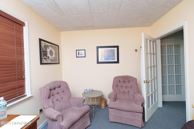 living area with carpet, french doors, and a paneled ceiling