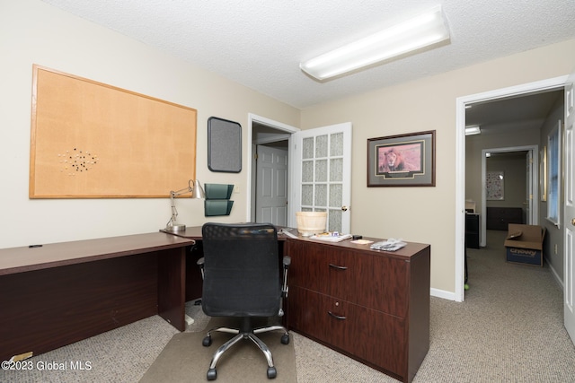 carpeted office featuring a textured ceiling