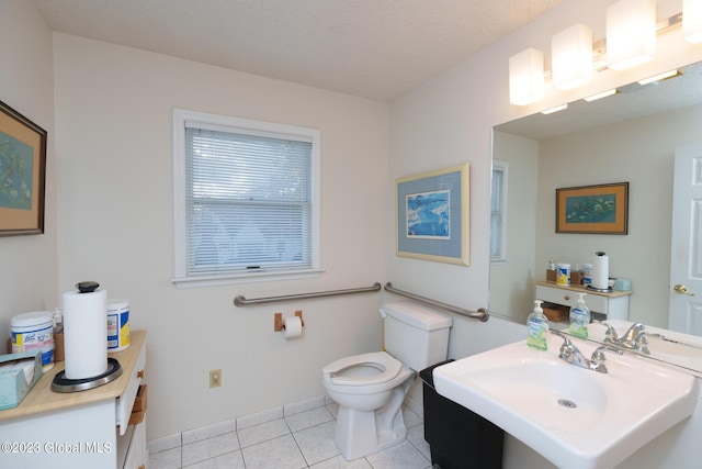 bathroom featuring toilet, tile patterned flooring, a textured ceiling, and sink